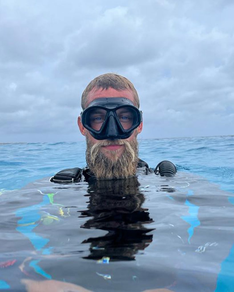 Headshot of Martijn. In the water wearing dive gear and a mask